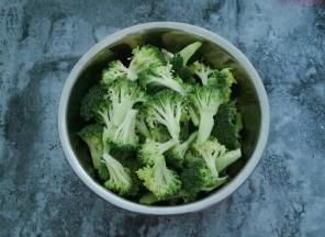 西兰花用刀切成小朵放在大一点的容器中，用水冲洗一下