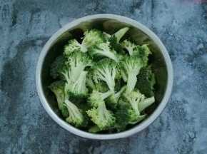 西兰花用刀切成小朵放在大一点的容器中，用水冲洗一下