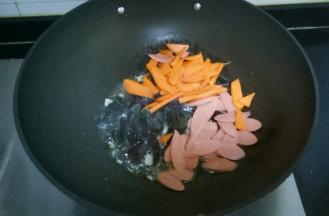 放入胡萝卜、火腿肠翻炒