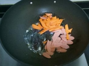 放入胡萝卜、火腿肠翻炒