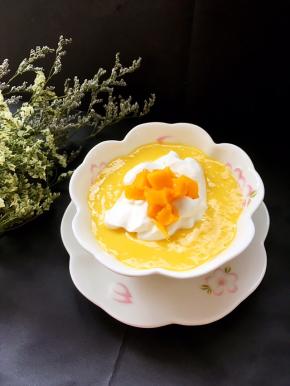 打好的奶昔装碗，上面挤上一点点打好的淡奶油，表面装饰点芒果丁即可