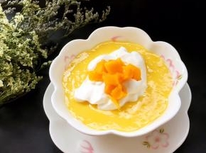 打好的奶昔装碗，上面挤上一点点打好的淡奶油，表面装饰点芒果丁即可