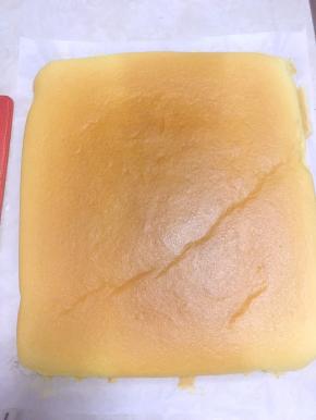 再磕几下，震出表层气泡，入烤箱烤25分钟，出炉从烤盘上拿下来，将四周的油纸剥下，等待凉透