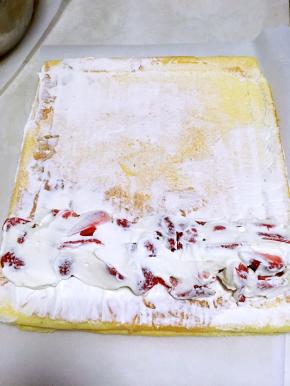 草莓上再抹点奶油，尤其是缝隙中，免得卷的时候草莓脱落