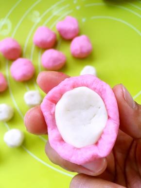 用粉色的水油皮材料包裹上油酥皮材料，将收口捏紧，醒个5分多钟