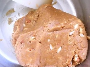 过筛面粉跟小苏打粉，搅拌几下，加入果仁搅拌均匀