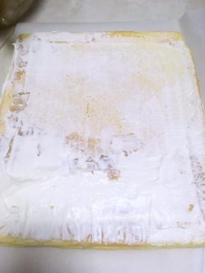 冰箱中取出打发的淡奶油，裱花袋的仍放冰箱冷藏，在蛋糕上抹一部分奶油，靠近自己这面多一点