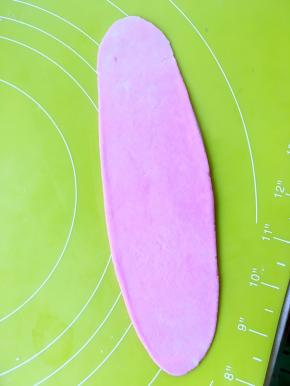 将包裹好的面团擀成长条，卷成牛舌状，盖上保鲜膜醒15分钟