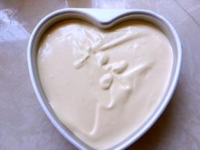 将翻拌好的面糊抬高20厘米倒入模具，用刮刀将表面抹平，之后再磕几下，震出气泡