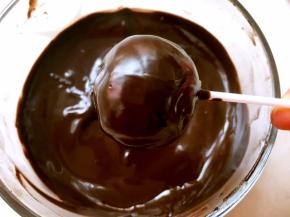  拿起一个棒棒糖，在巧克力液中滚一圈，让蛋糕均匀的裹上一层巧克力即可