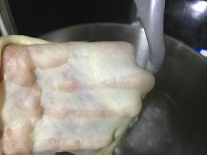 继续揉至面团的完全阶段，此时面团细腻柔软可拉出半透明的薄膜。