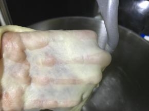 继续揉至面团的完全阶段，此时面团细腻柔软可拉出半透明的薄膜。