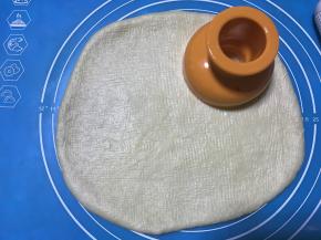 松弛好的面团檊成1CM厚的面片，用甜甜圈模具压出形状，如果面团不好擀说明松弛不到位，边角面片可重新整理擀开后用模具按压。