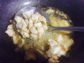 热锅倒油，油热加入腌好的鸡肉丁烹炸，炸制表面定型捞出沥干油份