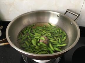 大火煮开后放入洗净的毛豆，加香叶，再加入盐，不用盖锅盖，转中小火煮十分钟
