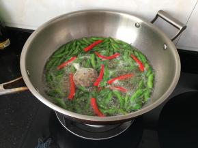 十分钟后加入辣椒，用剪刀把辣椒稍微剪破即可，继续敞开锅盖煮十分钟
