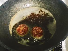 锅内倒油，油热，下肉丸煎炸，炸制表面变硬定型捞出，摆在盘中蒸锅大火蒸15-20分钟