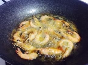 锅内热油，油热后，倒入腌好的大虾炸至表面金黄酥脆，取出备用
