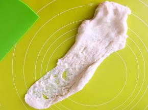 之后将面团倒在揉面垫上，一直向前推揉，将面团揉光滑