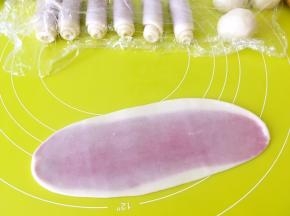 将松弛好的面团用擀面杖轻轻擀成长条，之后卷起来，卷成牛舌卷，盖保鲜膜松弛15分钟