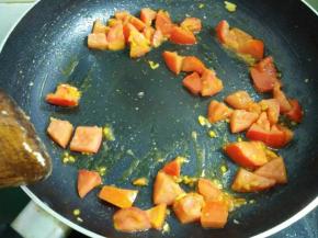 锅里倒入适量植物油将西红柿炒快熟出红汁。