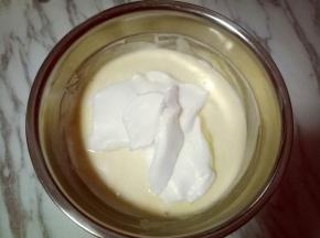 再取三分之一的蛋白霜加入蛋黄糊中，继续上面的手法，翻拌直至看不到蛋白霜。