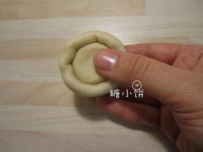 取一个油皮面团压扁，包入一个油酥面团。像包汤圆一样收口，搓圆。依次包好20个
（任何时候都要注意用保鲜膜盖好暂时不操作的面团以免表面风干！）