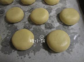 依次包好20个生坯，收口朝下放置，用手轻轻压扁成厚饼状
（底面垫的是油纸，看起来很多油是因为之前已经烤过一盘了，有出油）