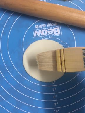 在饺子皮上撒少许盐，羊毛刷刷上色拉油