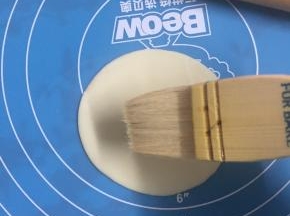 在饺子皮上撒少许盐，羊毛刷刷上色拉油