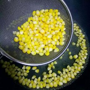 将煮熟的玉米粒捞出放碗中，（不要把水份控的太干，否则下一步玉米淀粉不能均匀的裹在玉米粒上）