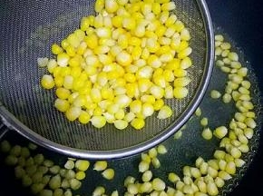 将煮熟的玉米粒捞出放碗中，（不要把水份控的太干，否则下一步玉米淀粉不能均匀的裹在玉米粒上）