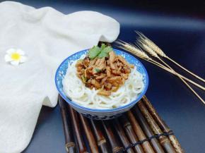 将肉丝酱盛入面条的碗中。