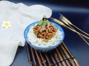 将肉丝酱盛入面条的碗中。