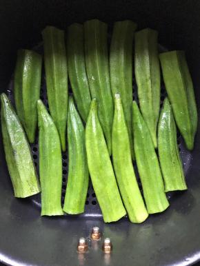 秋葵洗净去根，整齐摆放在空气炸锅里，200度5分钟烤干表面水份