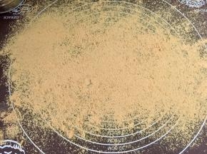 在揉面垫上筛一层黄豆粉。