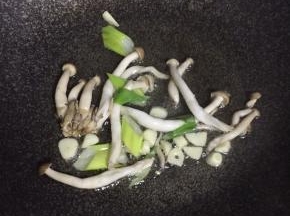 锅内热油倒葱姜蒜蘑菇翻炒出香味
