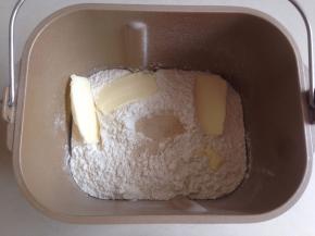 在面粉顶端加入酵母和黄油