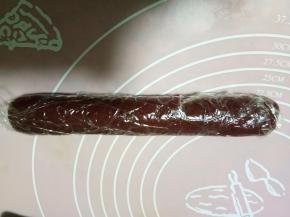 红色面团搓成圆柱长条，直径大约3.5厘米，包裹保鲜膜，放入冰箱冷冻半小时。