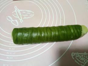 相同的方法再把绿色面团卷好。不借助保鲜膜的话就把面团分成无数个小剂子，搓成可以围上一步圆柱体一圈的小长条，然后一条条围在上步的圆柱面团上，这种方法比较难把握，不如铺保鲜膜擀面片容易操作。卷好以后包裹保鲜膜轻轻攥一下。放入冷冻层冻15分钟