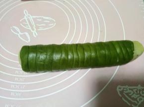 相同的方法再把绿色面团卷好。不借助保鲜膜的话就把面团分成无数个小剂子，搓成可以围上一步圆柱体一圈的小长条，然后一条条围在上步的圆柱面团上，这种方法比较难把握，不如铺保鲜膜擀面片容易操作。卷好以后包裹保鲜膜轻轻攥一下。放入冷冻层冻15分钟