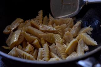 热锅下油，倒入透过水的笋翻炒