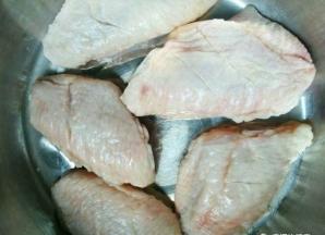 鸡翅清洗干净以后，用刀在鸡翅两侧划两道口。