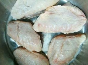 鸡翅清洗干净以后，用刀在鸡翅两侧划两道口。