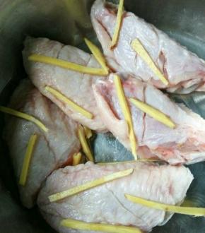 生抽加一些水，再放姜丝进去，准备腌鸡翅。把兑了水的生抽和姜丝，放到鸡翅里，再用手给鸡翅按摩下，会比较入味，腌二十分钟。