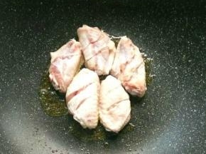 待姜片炒的有点焦的时候，取出，放入鸡翅，待一面煎熟，能推动的时候，再翻面。