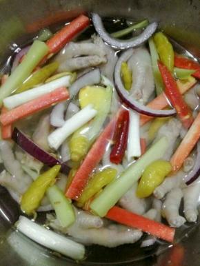 把煮熟的鸡爪放入一个盘中，放入泡椒，洋葱及所有调料浸泡，浸泡一个晚上