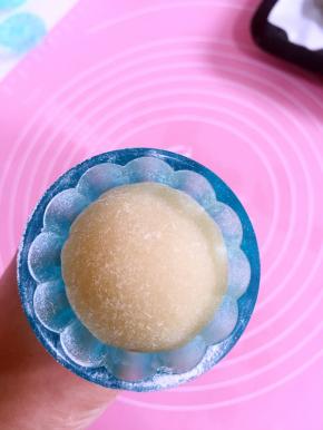 把滚好粉的月饼胚放进模具中！轻轻按压一下！（这个时候可以把烤箱预热了！200度预热10分钟！）