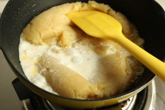 热好的牛奶倒入土豆泥里，继续炒。