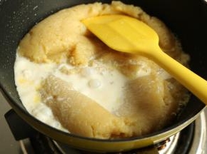 热好的牛奶倒入土豆泥里，继续炒。